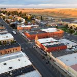 Ritzville WA 9 Aerial view of Ritzville, WA, showing brick buildings, streets lined with parked cars, and open fields in the background under a partly cloudy sky.